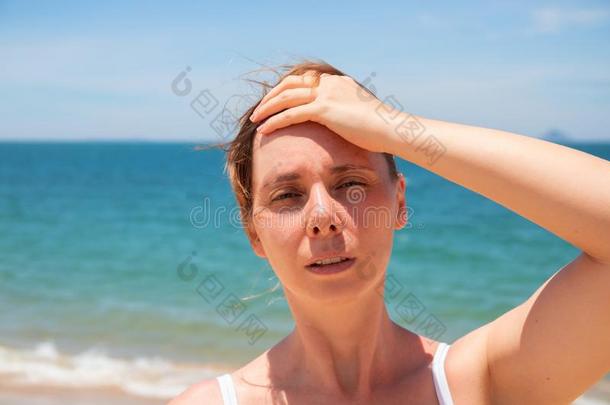 女人和头痛向和煦的：照到阳光的海滩.年幼的女人所有<strong>中暑</strong>