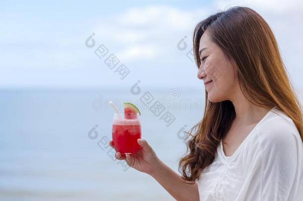 一女人喝饮料西瓜果汁在期间一次在旁边指已提到的人海