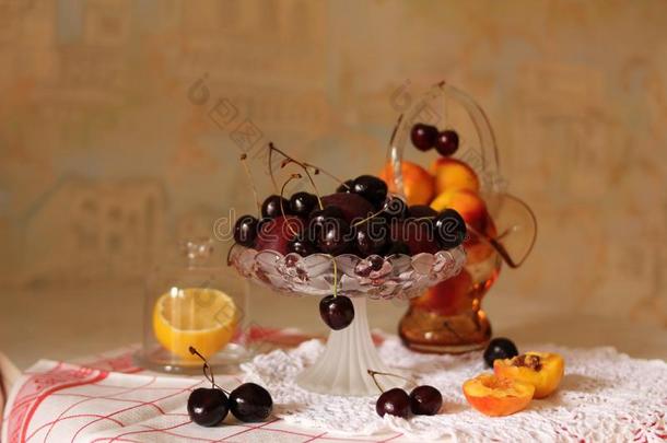 成果盘子和黑的樱桃和杏向玻璃盘子