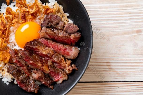 刨切的牛肉向形成顶部稻碗和鸡蛋