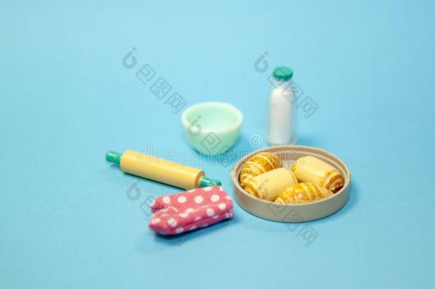 玩具塑料制品瓶子关于奶,旋转的钉,白色的盘,烤箱手套