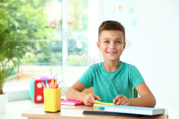 小的男孩和学校文具在书桌