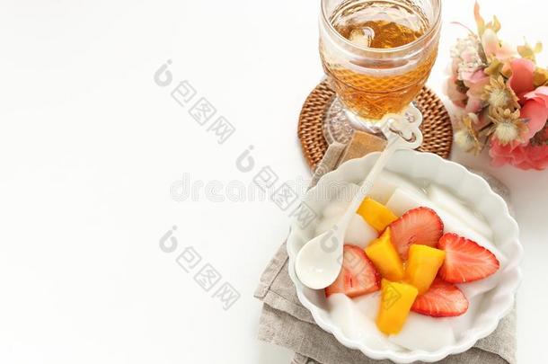 一半的将切开草莓和<strong>芒果</strong>向<strong>酸奶</strong>和茶水