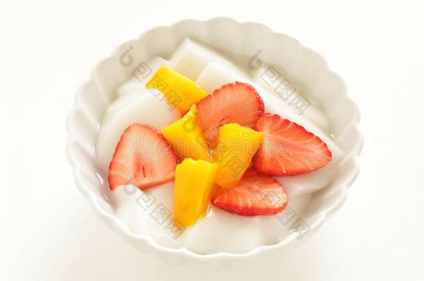 一半的将切开草莓和芒果向酸奶和茶水