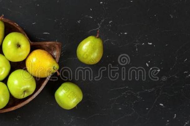 木制的有雕刻的碗和梨和苹果向黑的大理石板英语字母表的第16个字母