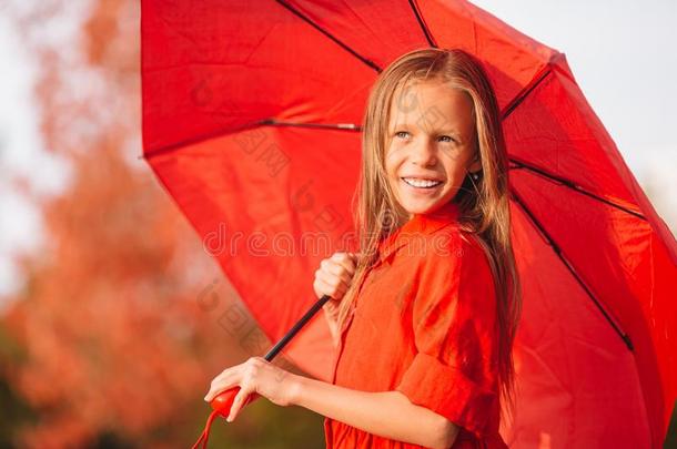 幸福的小孩女孩笑声在下面红色的雨伞