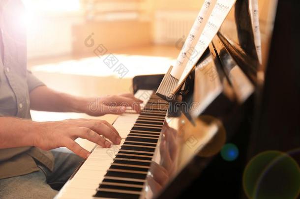 男人演奏钢琴在室内.音乐教训
