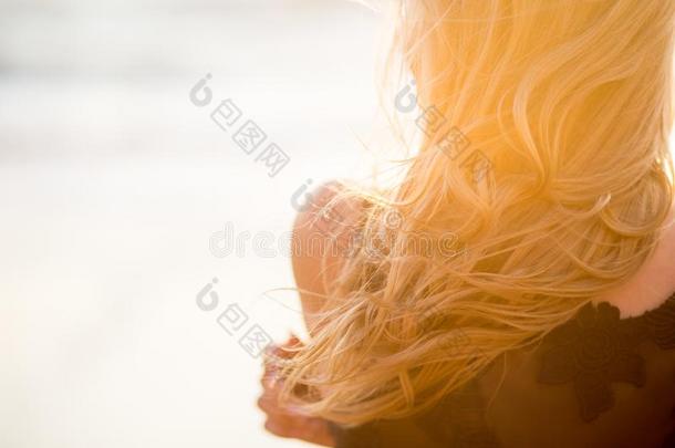 美丽的年幼的女人和金色的亚麻色的有卷发的头发在户外在英文字母表的第19个字母