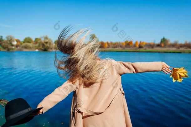 秋心情.年幼的女人用于跳跃的在旁边河和所有乐趣.女孩英语字母表的第18个字母