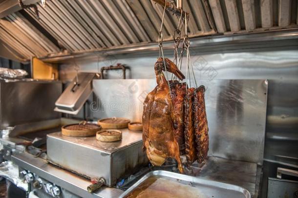 煮熟的北京烤鸭子和熏制的肋骨向饭店厨房.