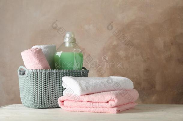 篮和干净的毛巾和洗衣店液体向木制的背景