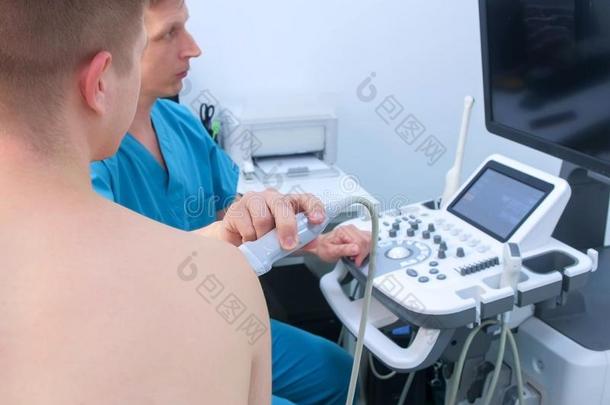 医生使超声关于肩膀共同的为男人使用超声波