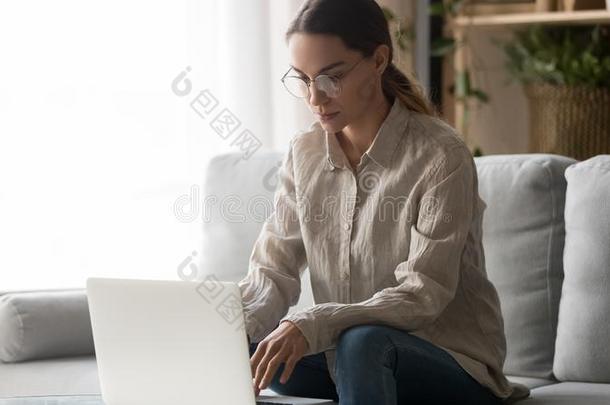 聚焦的年幼的女人学习工作的从家打字向便携式电脑