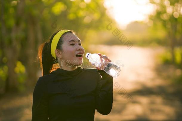 年幼的亚洲人赛跑者女孩喝饮料水<strong>浑身</strong>出汗的和疲倦的.吸引