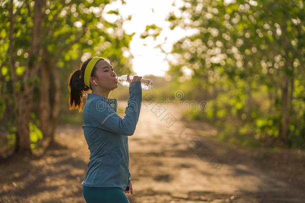 年幼的亚洲人赛跑者女孩喝饮料水<strong>浑身</strong>出汗的和疲倦的.吸引