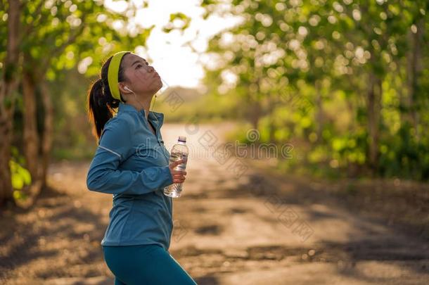 年幼的亚洲人赛跑者女孩喝饮料水<strong>浑身</strong>出汗的和疲倦的.吸引