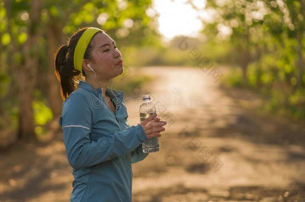 年幼的亚洲人赛跑者女孩喝饮料水<strong>浑身</strong>出汗的和疲倦的.吸引