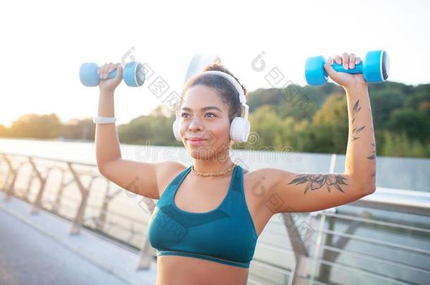 年幼的<strong>刺青</strong>女人建筑物她肌肉在期间工作的出局