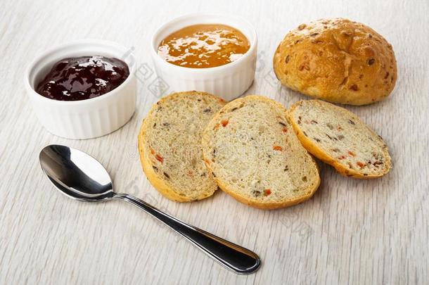 保龄球和果酱,勺,圆形的小面包或点心,部分关于圆形的小面包或点心向木制的表