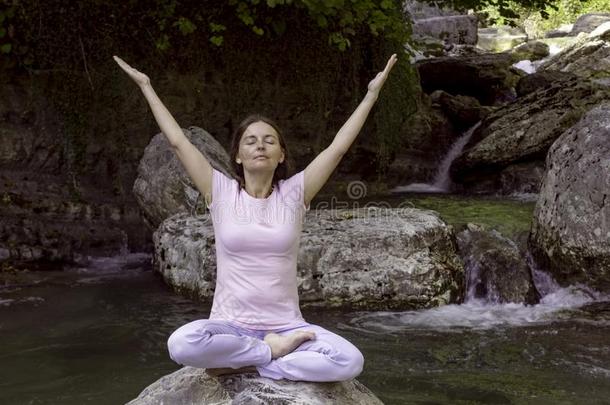 女人是（be的三单形式开业的瑜伽采用莲花使摆姿势在mounta采用湖