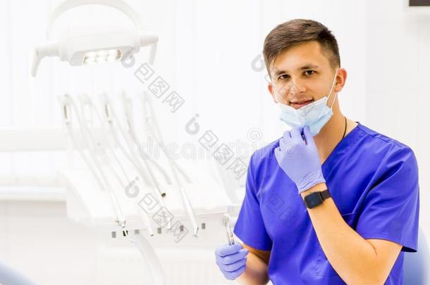 医生使人疲乏的蓝色采用他的牙科医生办公室和look采用g在照相机