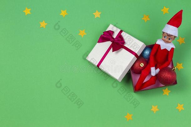 圣诞节背景.红色的玩具小精灵一次采用现在的盒,圣诞节英语字母表中的第四个字母