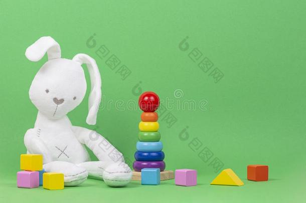 白色的豪华的玩具兔子,婴儿堆垛戒指金字塔和富有色彩的