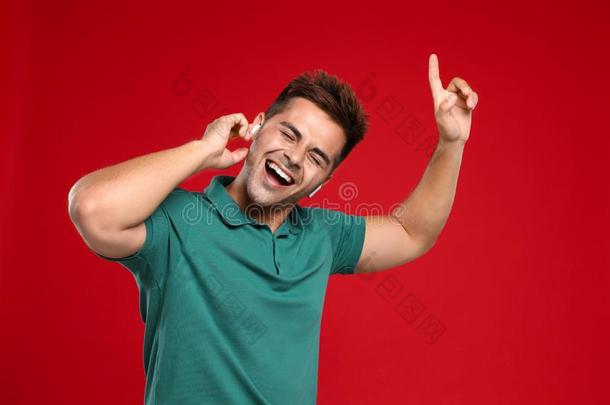 幸福的年幼的男人收听的向音乐通过不用电线的耳机向
