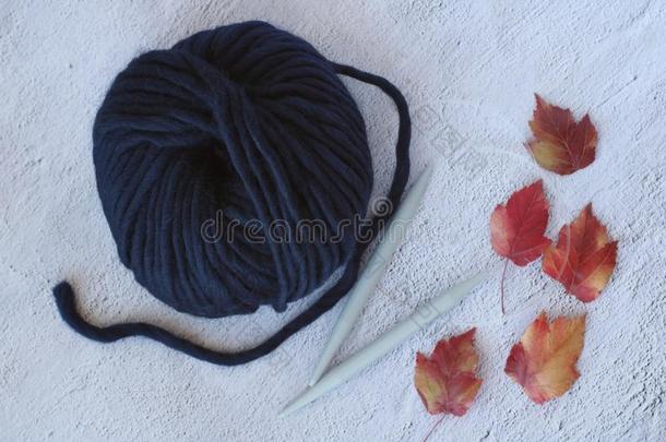 黑暗的蓝色羊毛纱和金属针经过枫树树叶,奥图姆