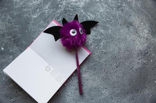 时髦的紫色的蝙蝠铅笔和粉红色的笔记簿为记下向灰色的用绳子拖的平底渡船