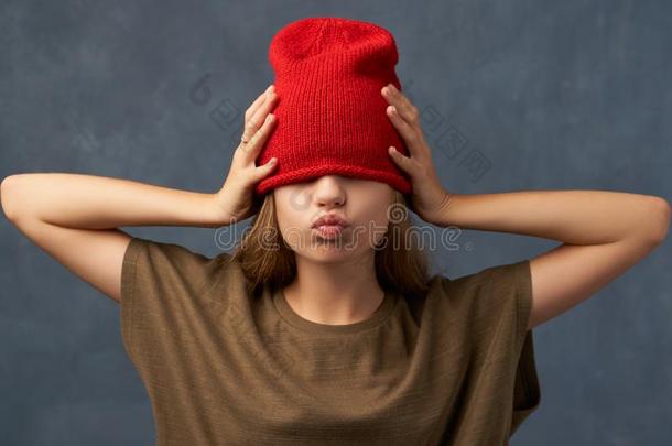 十几岁的青少年拉下红色的帽子,遵守眼睛关闭着的