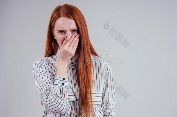 坏的嗅觉不幸的红发的人商业女人采用一有条纹的衬衫拿住