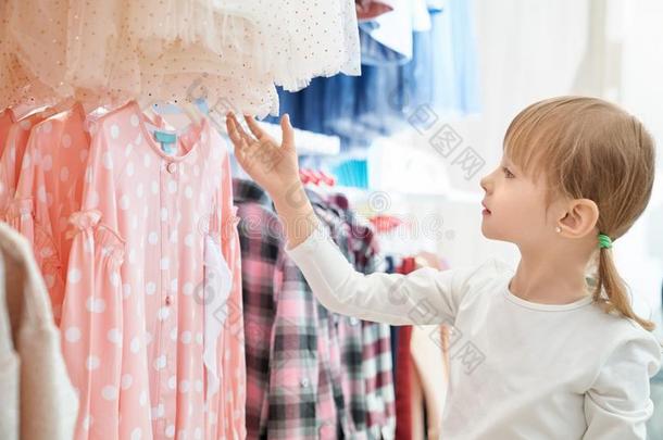 有趣的女孩有样子的在可爱的粉红色的衣服采用商店