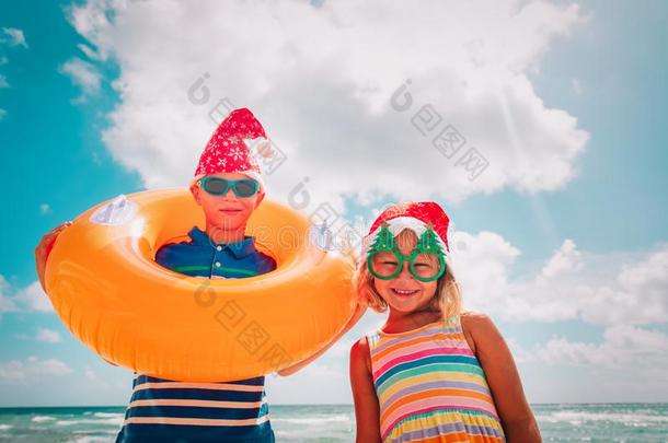 幸福的小孩-男孩和女孩-庆祝圣诞节向海滩