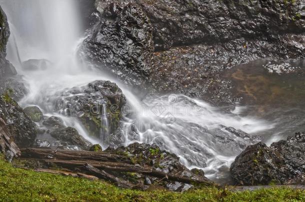 瀑布水使溅起在底部和力向多岩石的园林景观