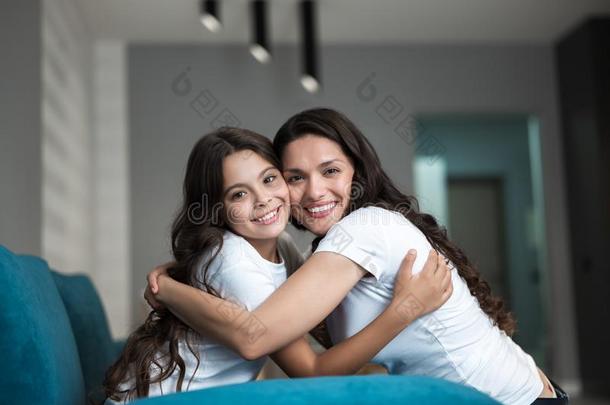 美丽的年幼的母亲和她漂亮的十几岁的青少年女儿热烈地拥抱eac每