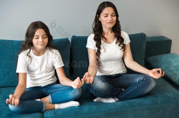 年幼的美丽的母亲和她青少年女儿一次采用瑜伽便壶