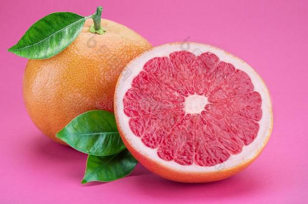 葡萄柚和葡萄柚切成片隔离的向粉红色的背景