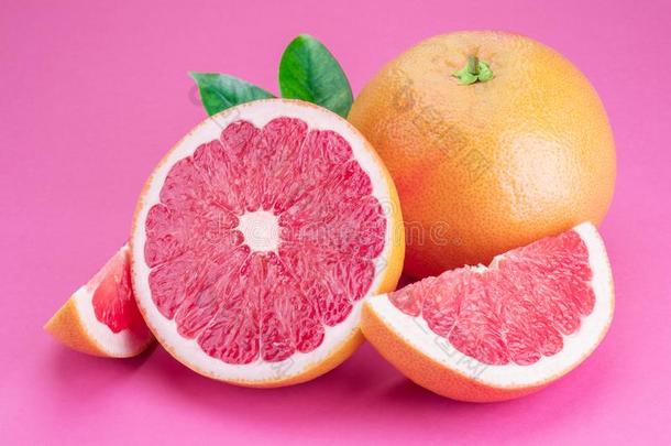 葡萄柚和葡萄柚部分隔离的向粉红色的背景