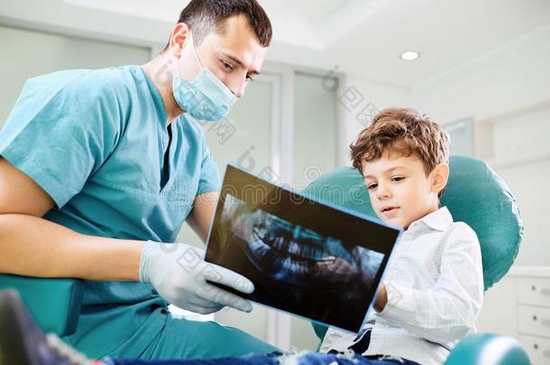 男孩小孩和牙科医生看在字母x-射线影像