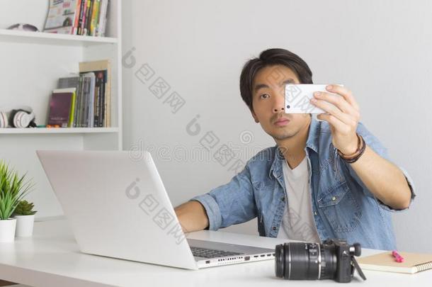 亚洲人摄影师或自由作家自拍照或拿照片在旁边聪明人