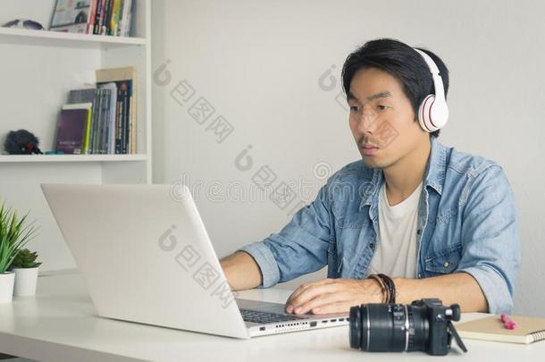 亚洲人自由作家电视录像制作人校核多媒体声音在旁边便携式电脑