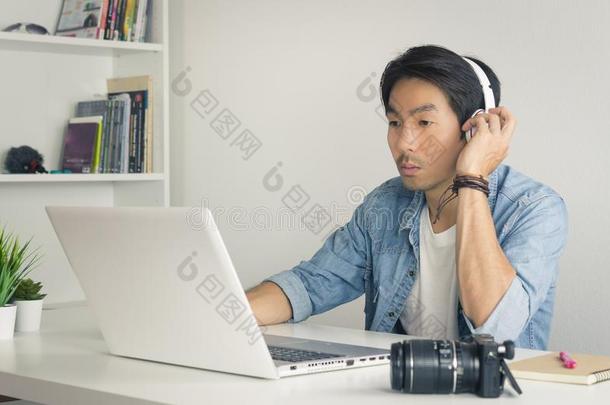 亚洲人自由作家电视录像制作人测试多媒体声音在旁边便携式电脑