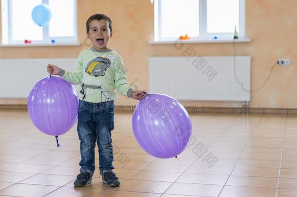 小的男孩和大的气球.幸福的小孩和紫色的气球采用