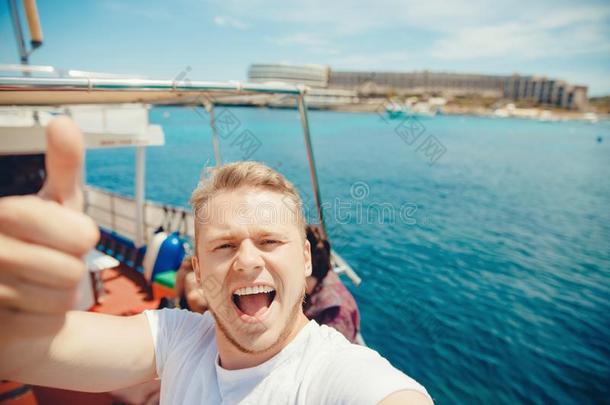 旅行支票男人拿自拍照照片向巡游班轮,船为旅行