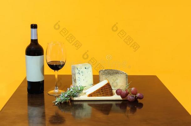 瓶子和玻璃关于红色的葡萄酒,奶酪板,葡萄,无花果和面包