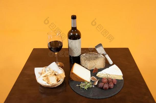 瓶子和玻璃关于红色的葡萄酒,奶酪板,葡萄,无花果和面包