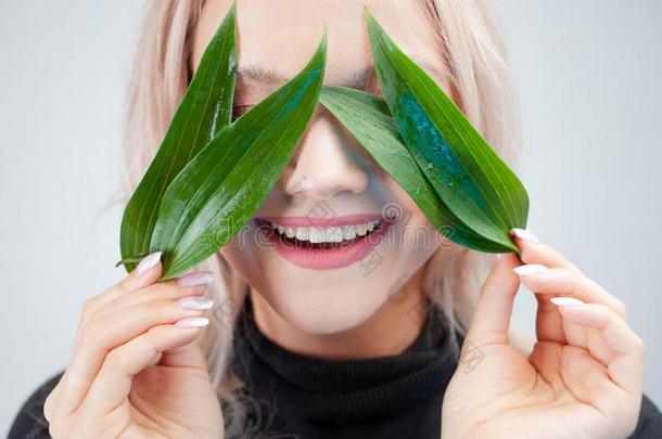 自然的美容品,观念.迷人的白肤金发碧眼女人使指已提到的人花瓣关于