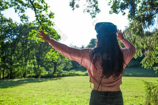 实质上的森林.年幼的女人采用VirtualReality虚拟现实眼镜看台在下面指已提到的人树