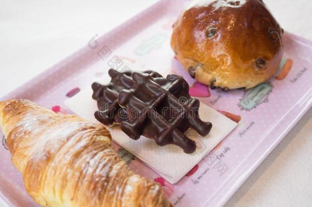 羊角面包,巧克力华夫饼和巧克力炸马铃薯条圆形的小面包或点心向一粉红色的Poland波兰